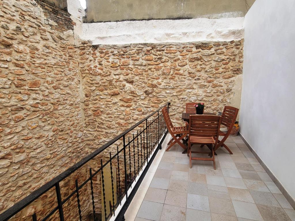 a table and chairs sitting next to a stone wall at Casa ALFANG in Torrent