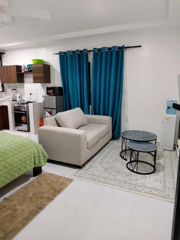 a living room with a couch and a table at Diani Beach Studio with Pool, Beach Access in Diani Beach