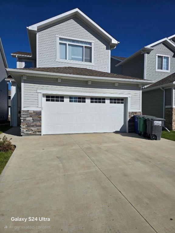 a house with a white garage door in a driveway at Omos Home in Saskatoon