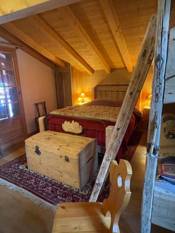 a bedroom with a bed and a wooden floor at Aux lits du bronze Le mole in Mont-Saxonnex