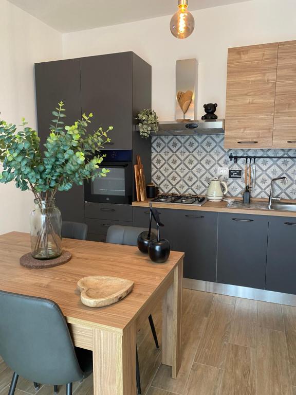 a kitchen with a wooden table with a vase of flowers at CasadiCampo in Scauri