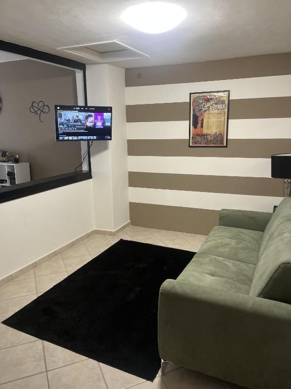 a living room with a couch and a flat screen tv at Eporedia Inn in Ivrea
