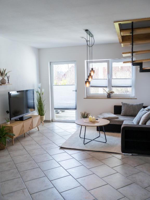 a living room with a couch and a tv at Ferienwohnung Allgäuherz in Obergünzburg