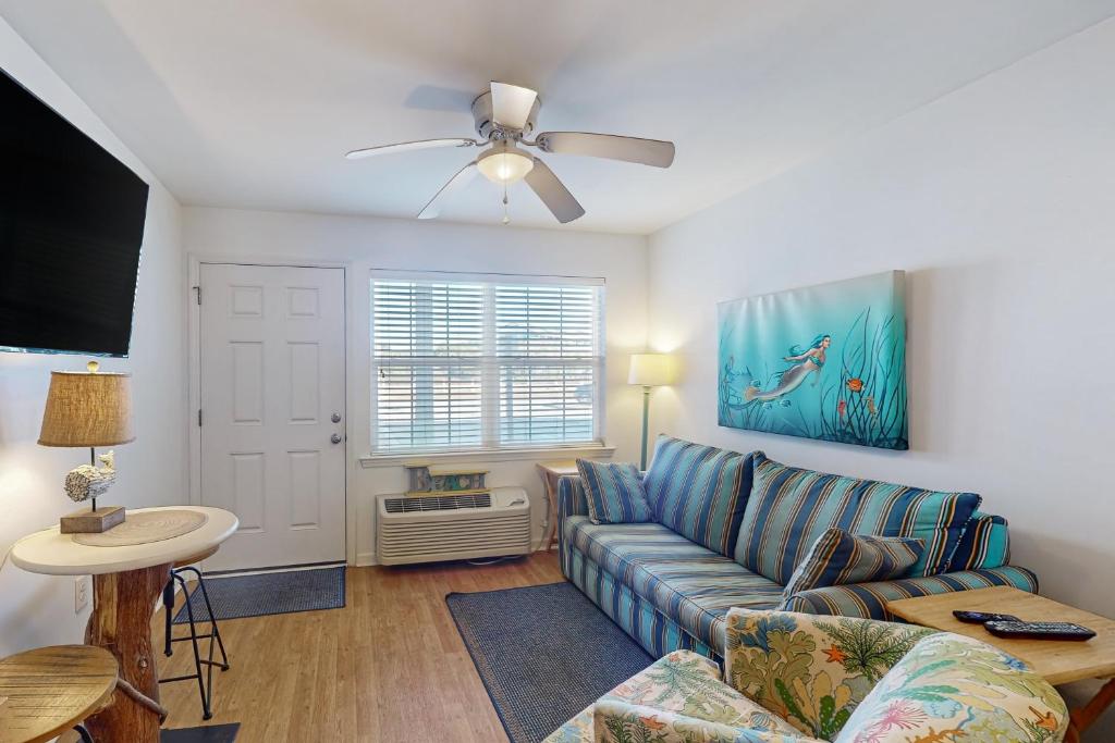 a living room with a blue couch and a ceiling fan at ABOS147 Ocean Sands 136 in Atlantic Beach
