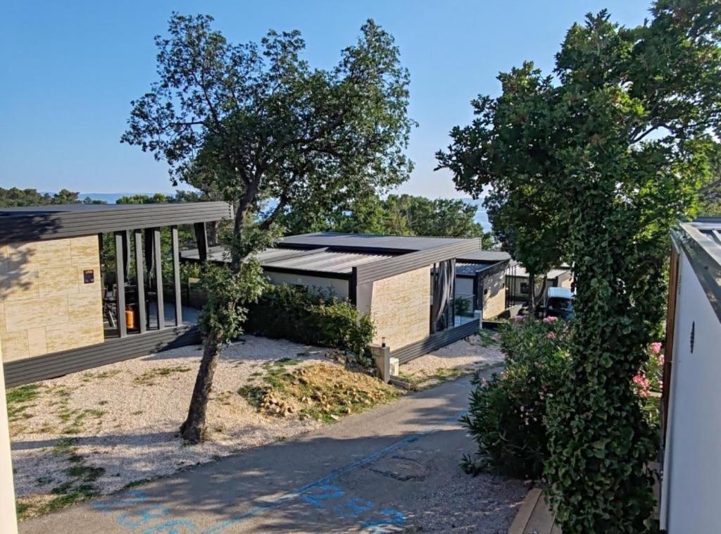 a house with a black roof and a tree at Mobile Home Annika Mar in Selce