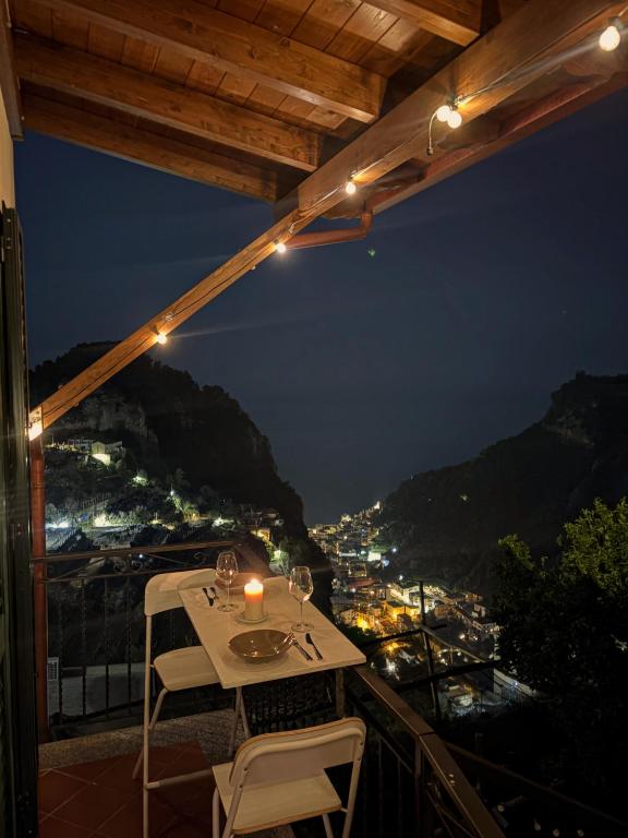 a table and chairs on a balcony at night at Armando's House in Pontone