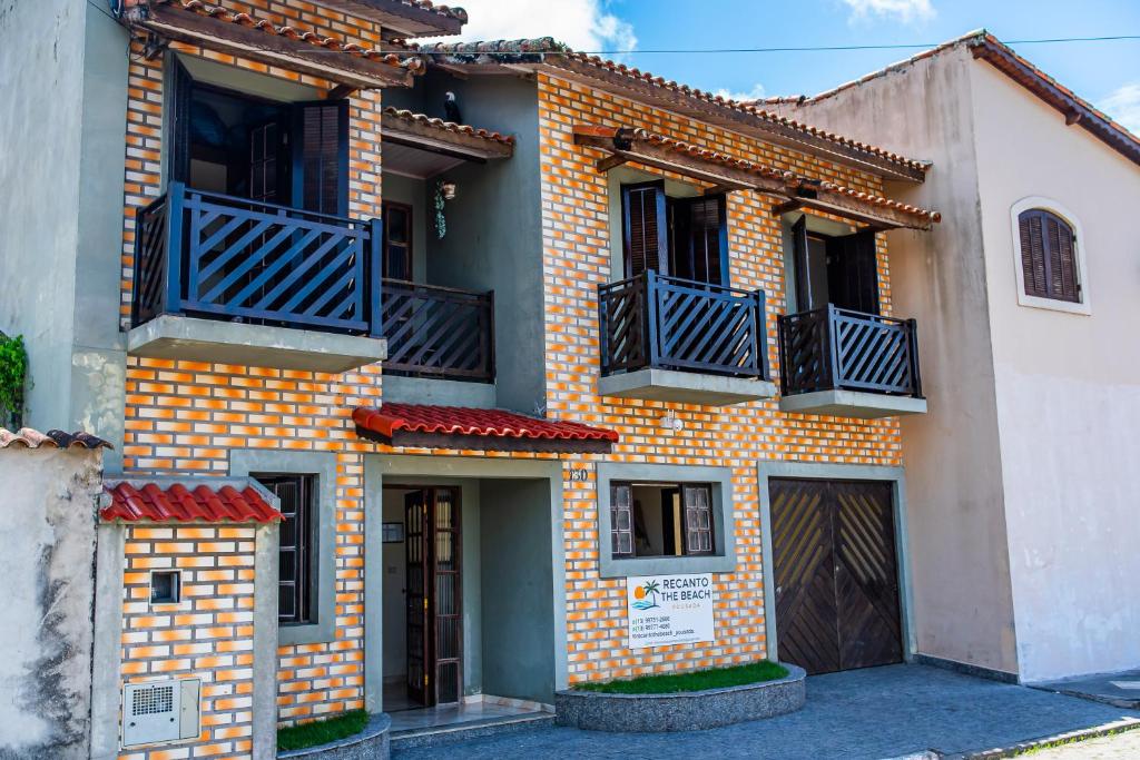 an orange and yellow brick house with black balconies at Recanto the beach pousada in Iguape