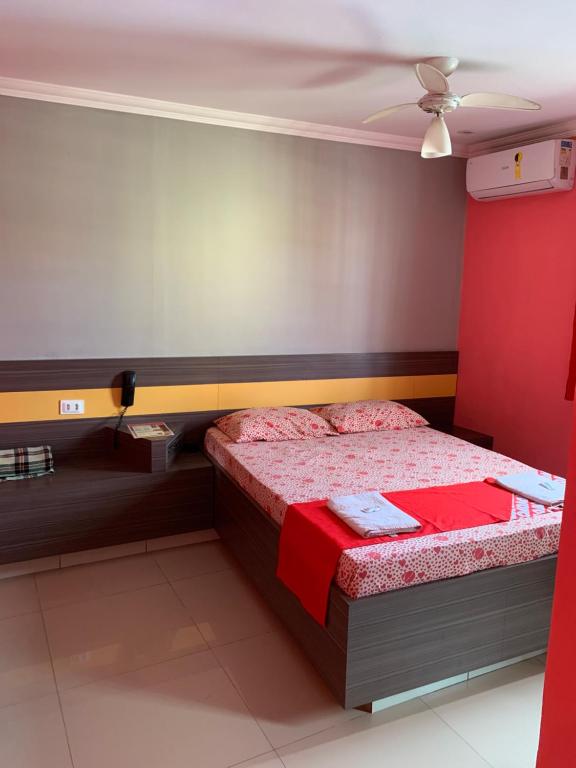 a bedroom with a bed with red sheets and a ceiling at Hotel Lalique in São Paulo