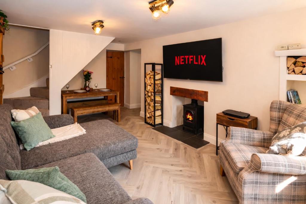 a living room with two couches and a fire place at Fellside Cottage in Shap