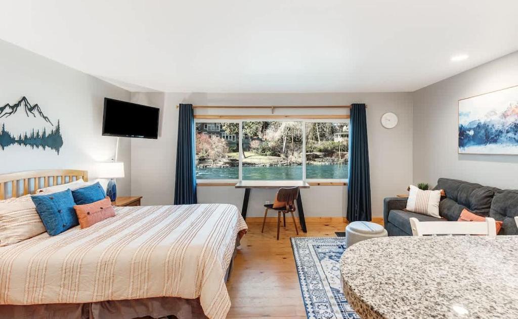 a bedroom with a bed and a couch and a desk at Cozy Studio Cottage on the River in Bend
