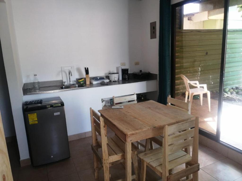 a kitchen with a wooden table and chairs and a counter at Casa Debut Surf Place 2 in Parrita