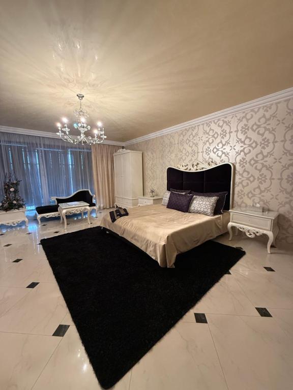 a bedroom with a large bed and a black rug at Lily Rose villa in Karlovy Vary