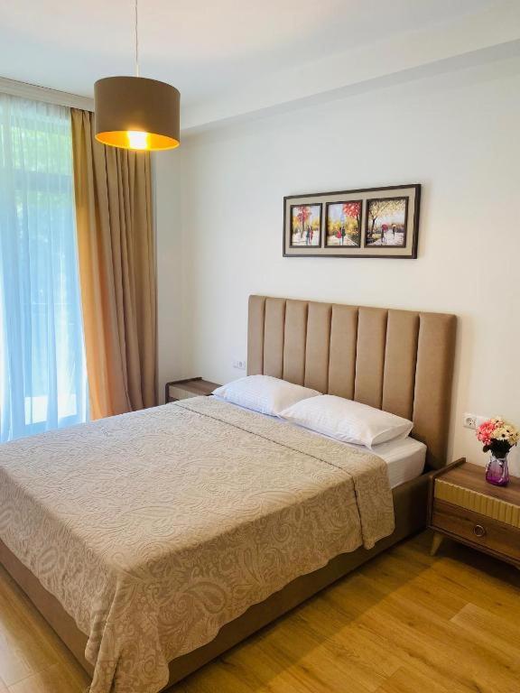 a bedroom with a bed and a large window at Holidays inkutaisi in Tsqnetʼi
