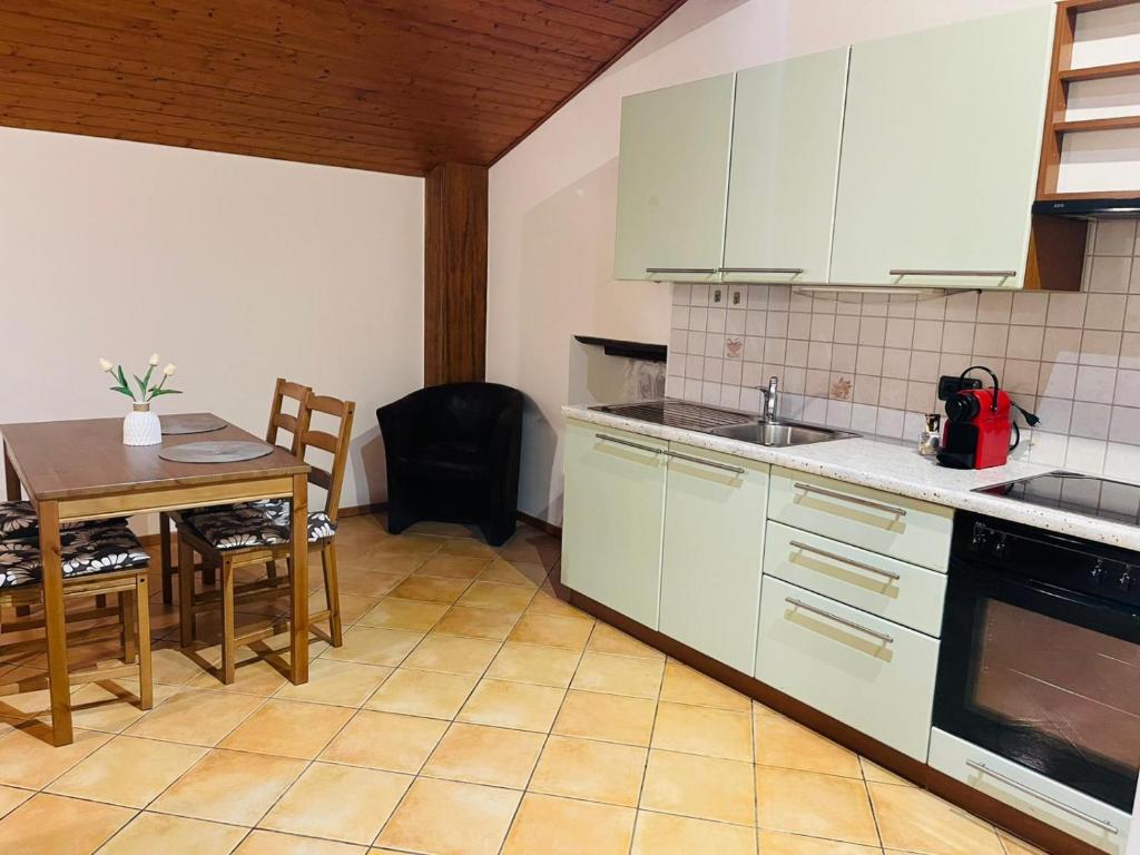 a kitchen with white cabinets and a table with chairs at Chiasso Swiss Apartment by RentuGoo Travel in Chiasso
