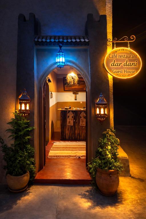 an entryway to a dark room with a sign and plants at DAR DANI café restaurant in Boumalne Dades