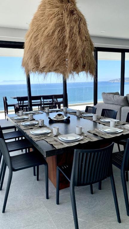 a large table with chairs and a large straw umbrella at Bantay 5f in Bucerías