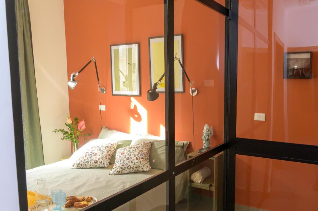ein Schlafzimmer mit einer orangefarbenen Wand und einem Bett in der Unterkunft Curò in Cinisi
