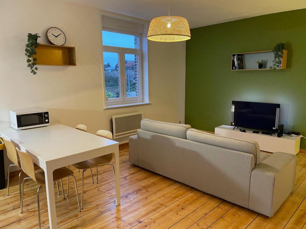 a living room with a couch and a table at Esprit Gare in Haubourdin