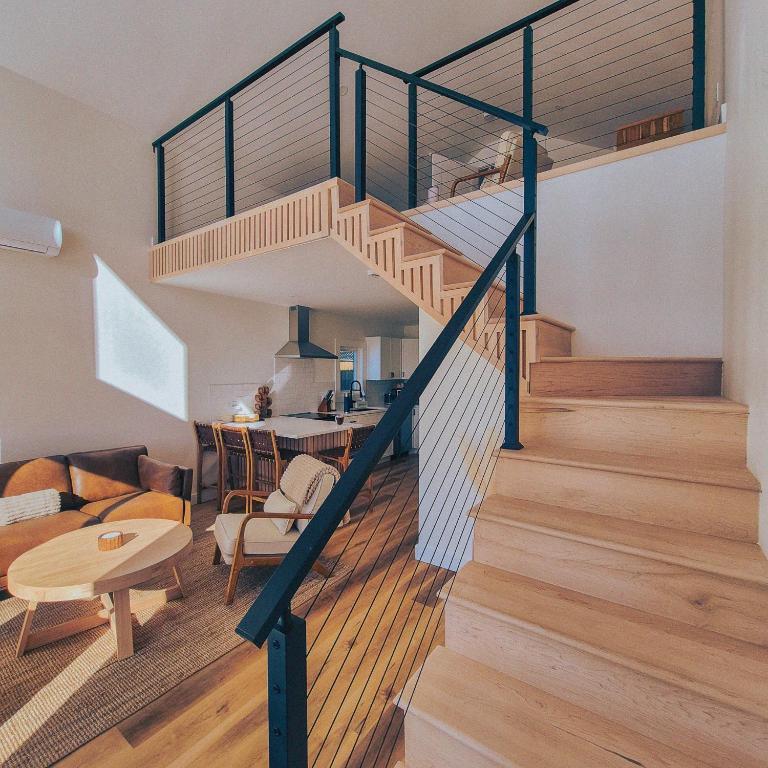 a spiral staircase in a living room with a table at Modern Nordic Cabin 2 Hot Tub & Views in East LaHave