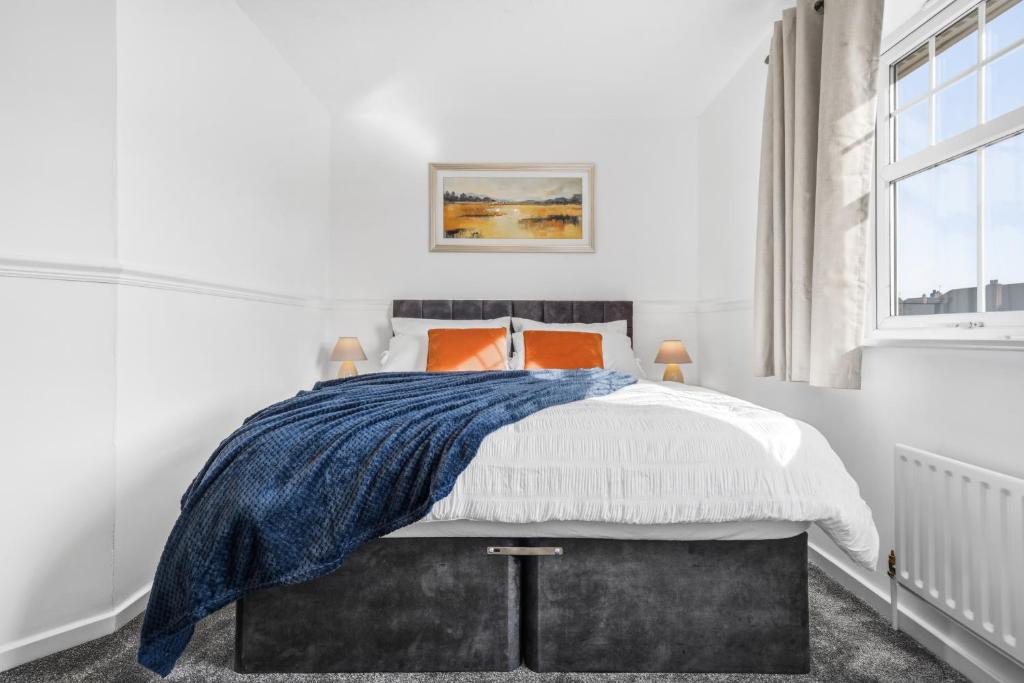 a white bedroom with a bed with orange pillows at HomeBase Midlands Contractors Relocation Parking in Walsall