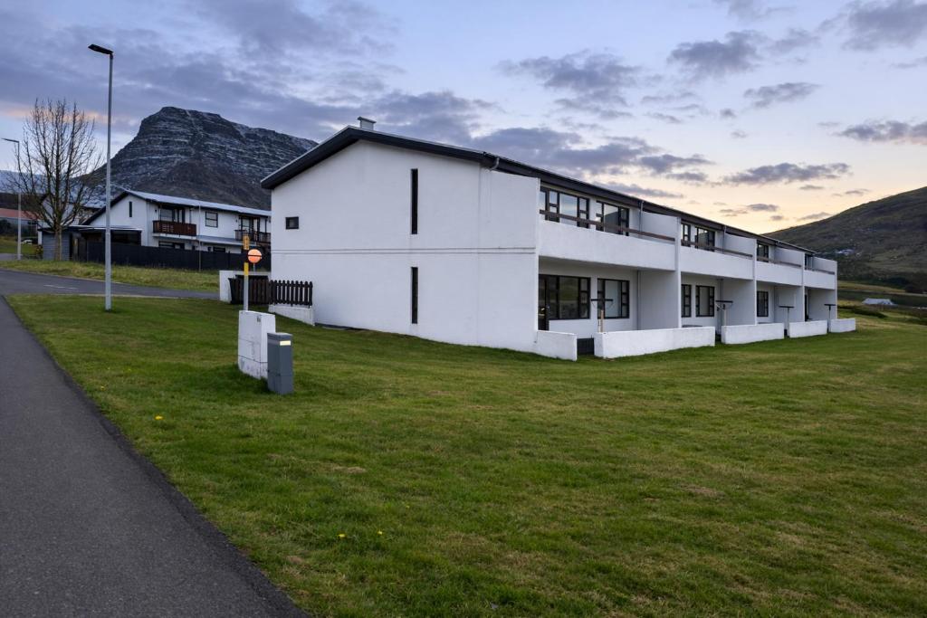 a large white building on a field of grass at Sigtun 55 in Patreksfjörður