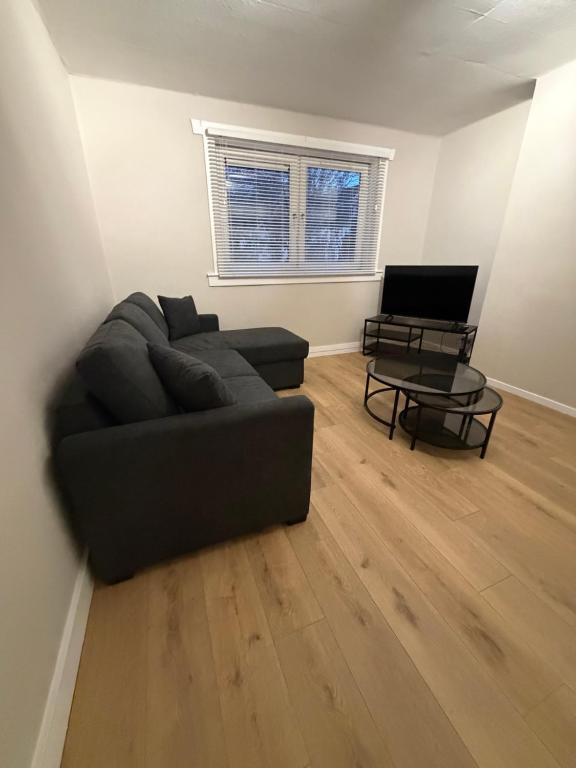 a living room with a couch and a table at Spacious 2 bed apartment with private parking space in Edinburgh