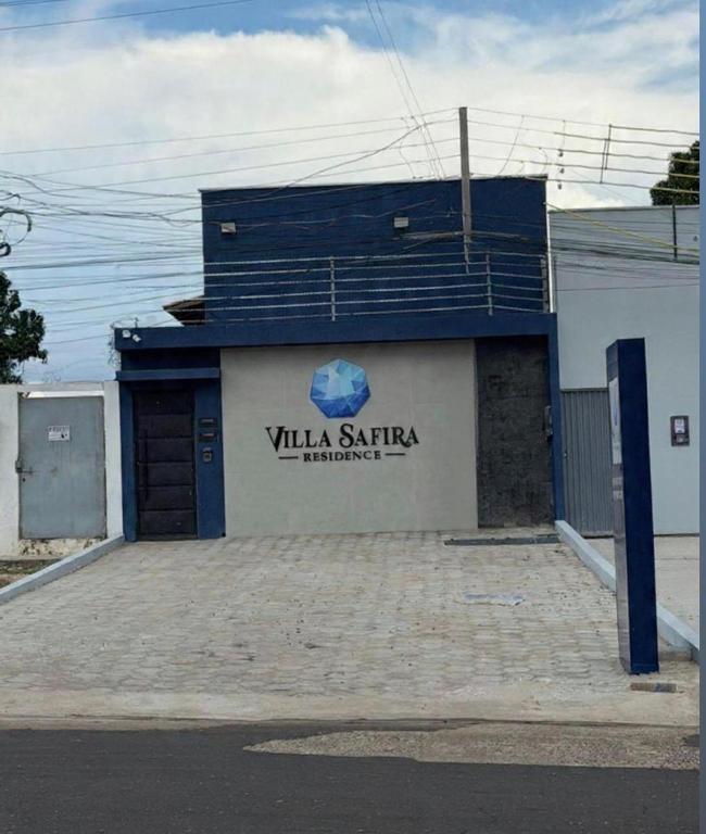 a blue and white building with a sign on it at Villa Safira Residence in Caxias das Aldeias Altas