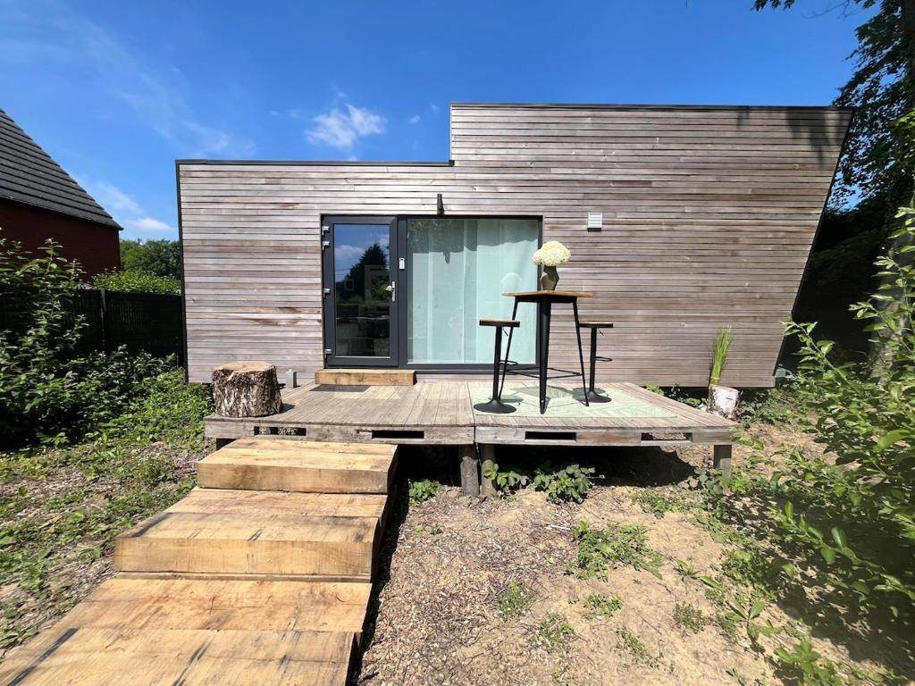 a small house with a table on a wooden deck at Le repère d Howardries in Brunehaut