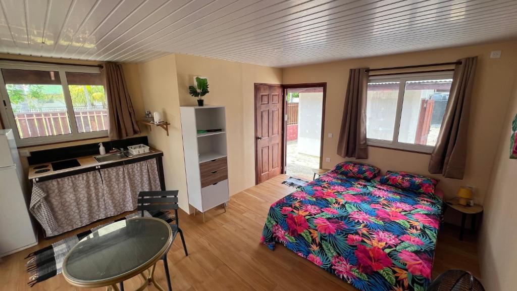 a bedroom with a bed and a desk and a table at Hiti Village G4 in Tikehau Airport