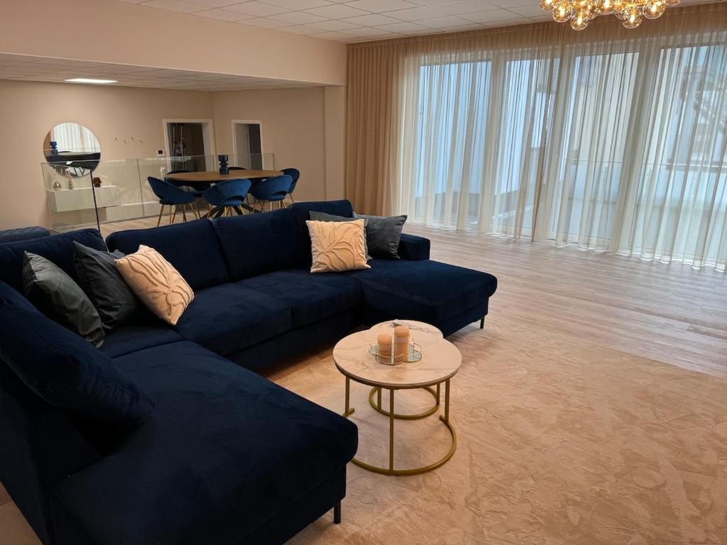 a living room with a blue couch and a table at City-Apartment Braunschweig in Braunschweig
