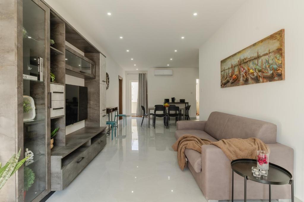 a living room with a couch and a table at 2 bedroom bright apartment in Gudja