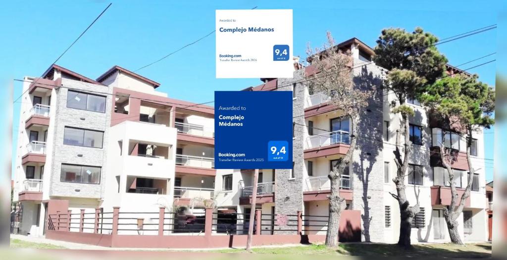 a building with a blue sign in front of it at Complejo Médanos in San Bernardo