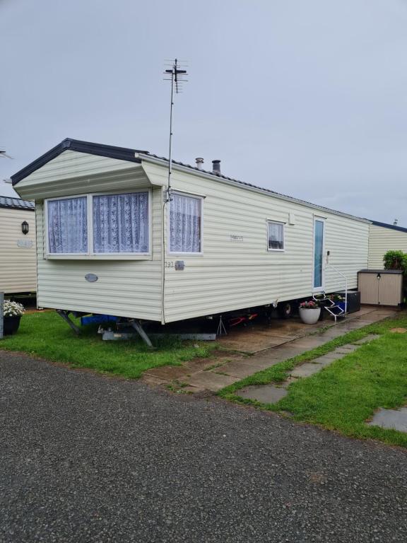 a house that is sitting in a yard at Caravan Galiccy in Kinmel Bay
