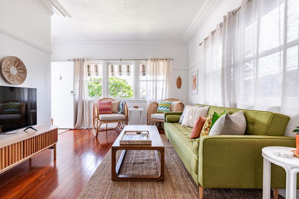 a living room with a green couch and a tv at Kaimana in Gold Coast