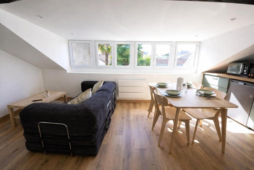 a living room with a couch and a table at Le Perchoir Charm and light in Pau