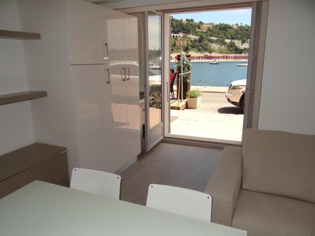 a kitchen with a table and chairs and a view of the water at Les pieds dans la mer Best place in Villefranche-sur-Mer