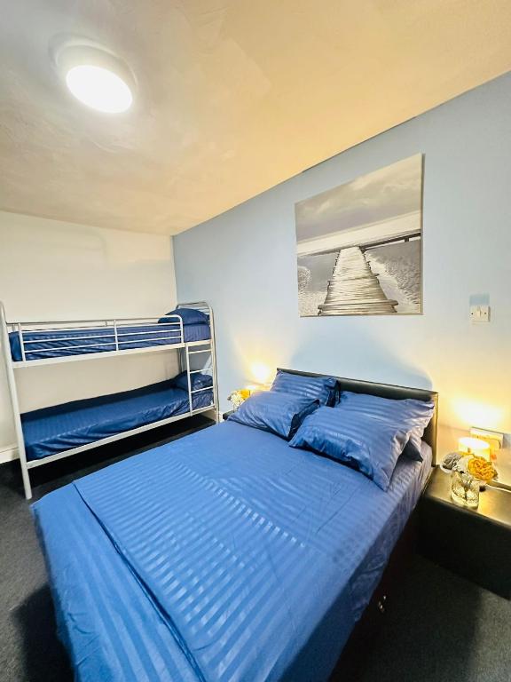 ein Schlafzimmer mit einem Bett mit blauen Laken in der Unterkunft Hotel Vibes in Blackpool
