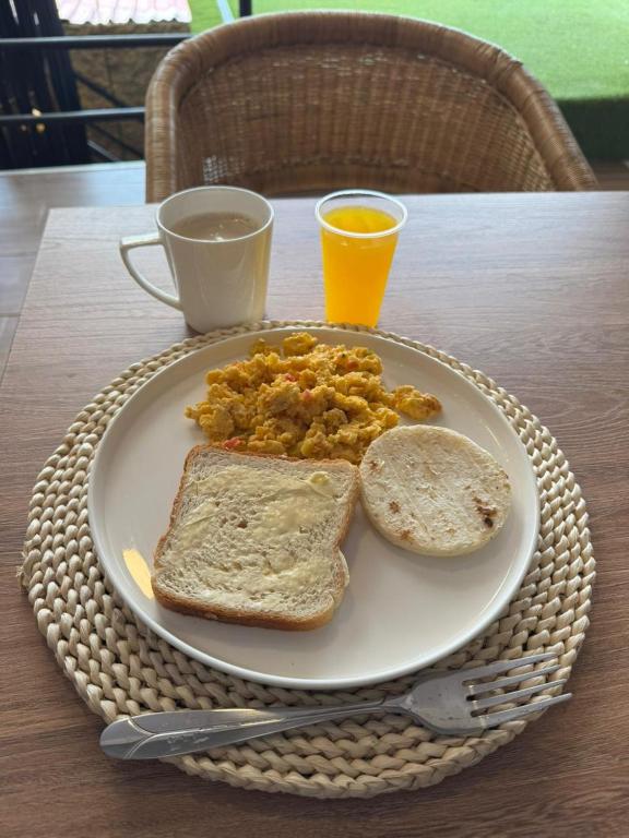 a plate of breakfast food with toast and orange juice at toba Hotel- 5 min Centro Ibague in Ibagué