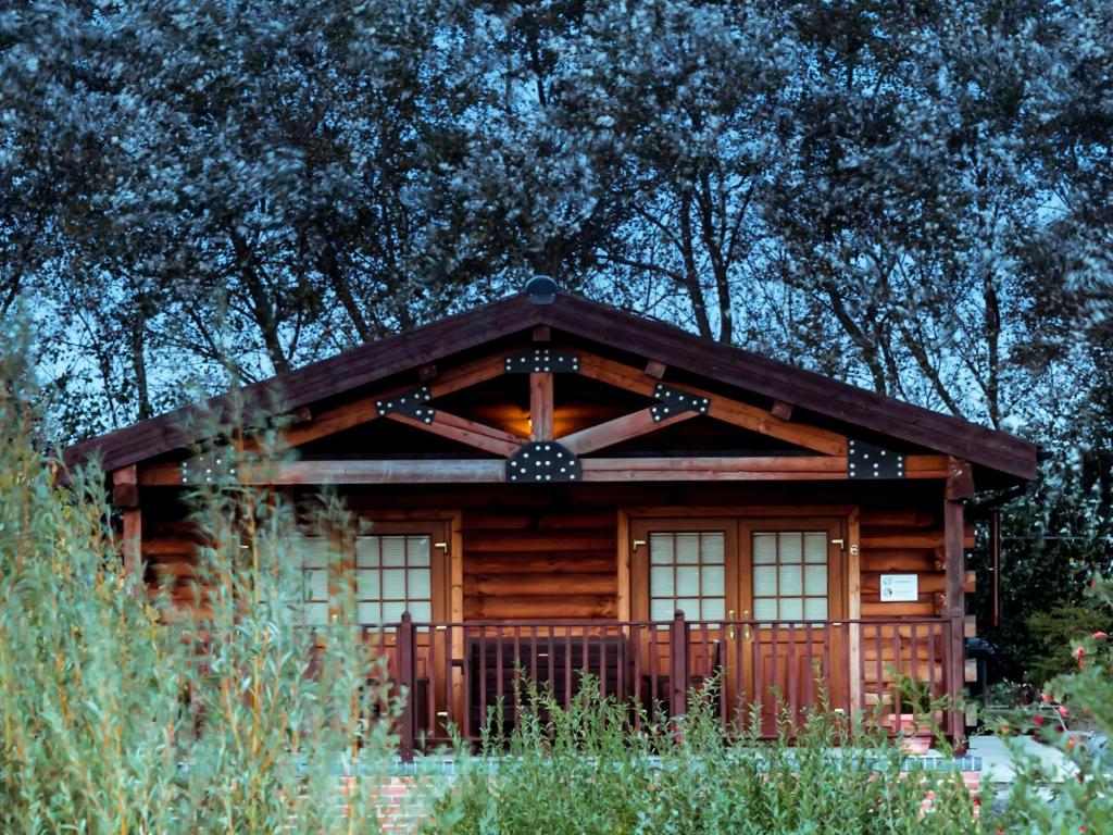 a log cabin with a wooden roof and windows at No 6 Lake View Lodges - 28283 in Old Leake