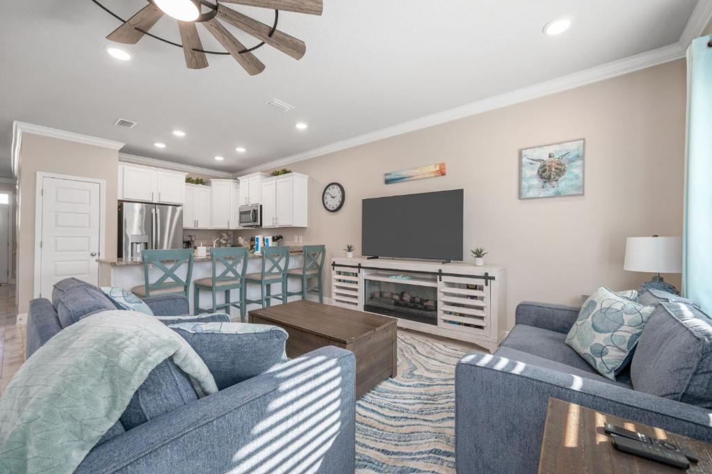 a living room with two blue couches and a tv at SEA-Bound STR in Pensacola