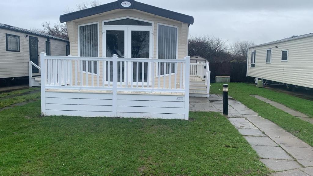 a small house with a gate in a yard at Lily's caravan in Meliden