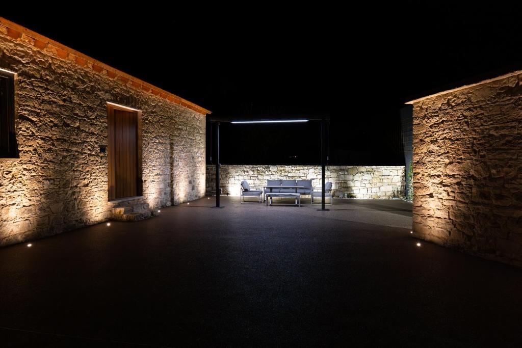a dark room with a couch in a brick building at Philoxenia Stone Suites in Choulou