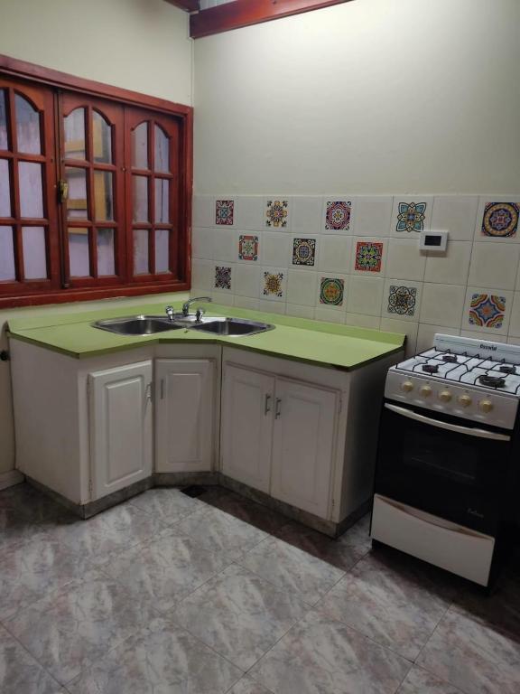 a kitchen with a sink and a stove at Impecable departamento en radar centrico in Ushuaia