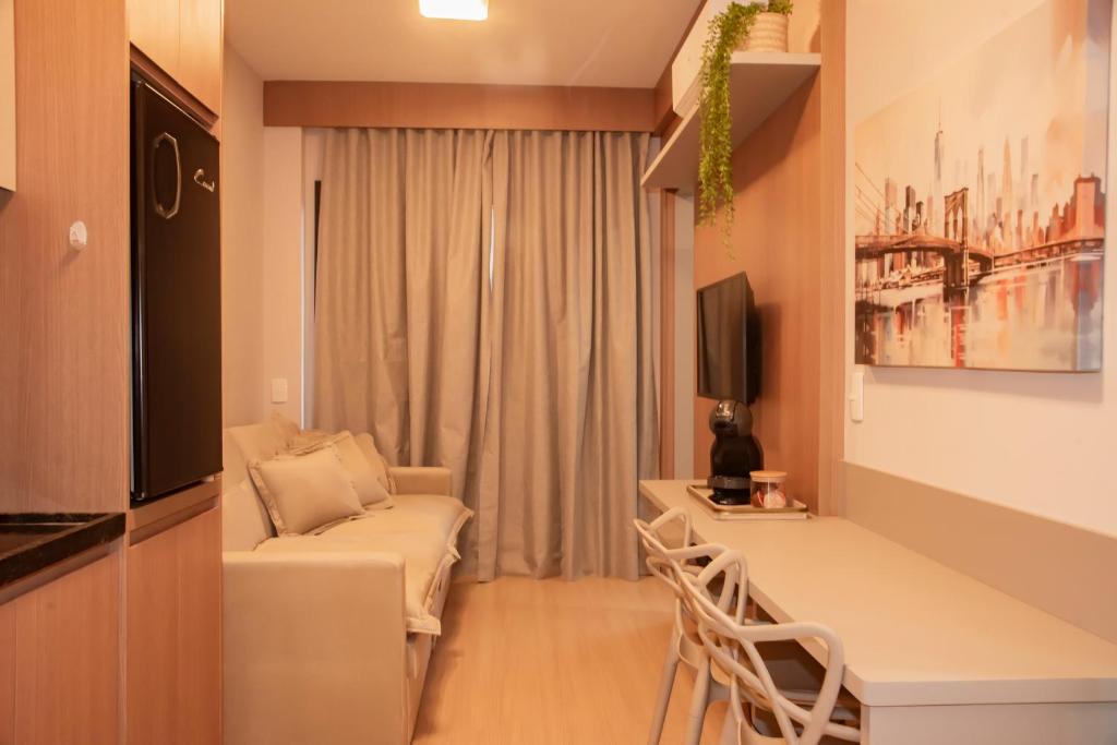 a small living room with a couch and a desk at Essential 2U in São Paulo