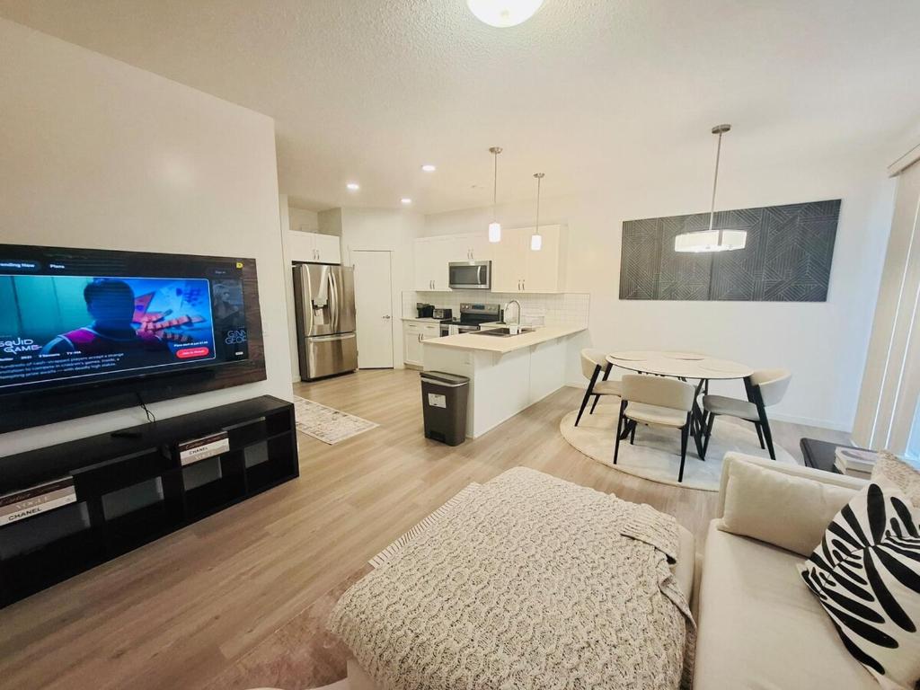 a living room with a couch and a tv and a table at Modern 4BDRM Home-2 King Bed- Full House in Edmonton