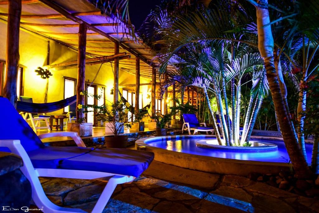 a patio with chairs and a fountain at night at Casa Lajagua in Pedasí Town