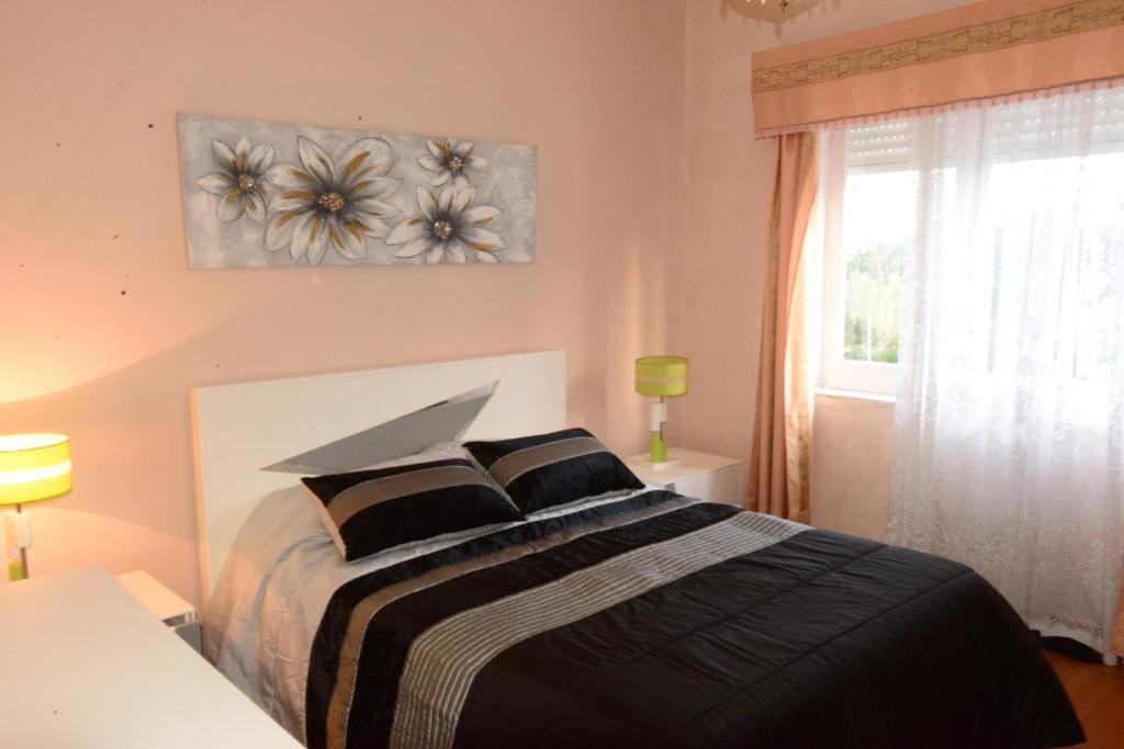 a bedroom with a bed with black and white sheets at Room 3 - Music House in Conceição