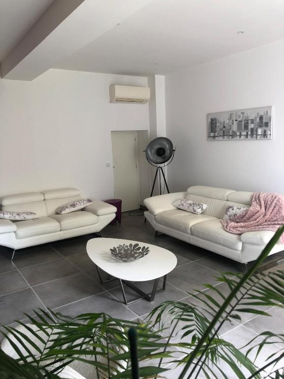 a living room with two couches and a table at Maison village entre pau et lourdes in Boeil-Bezing