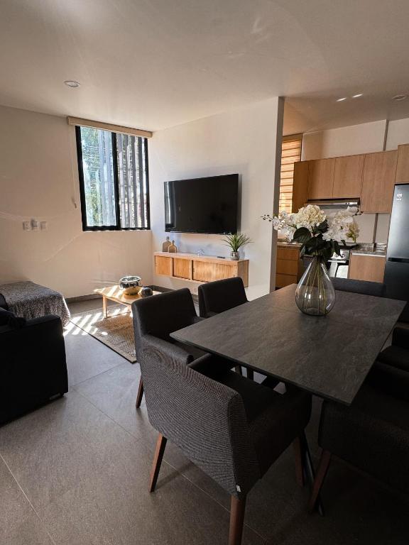 a living room with a table with chairs and a kitchen at Cielo Suites in Oaxaca City