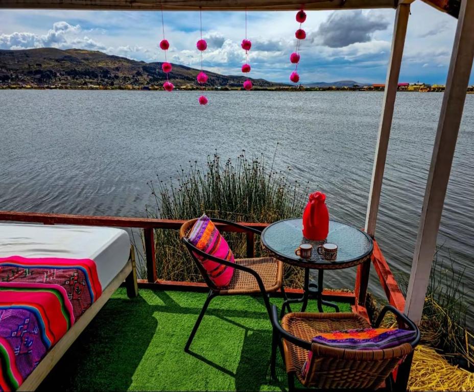a patio with a table and chairs next to the water at Sol del Titikaka Lodge in Puno